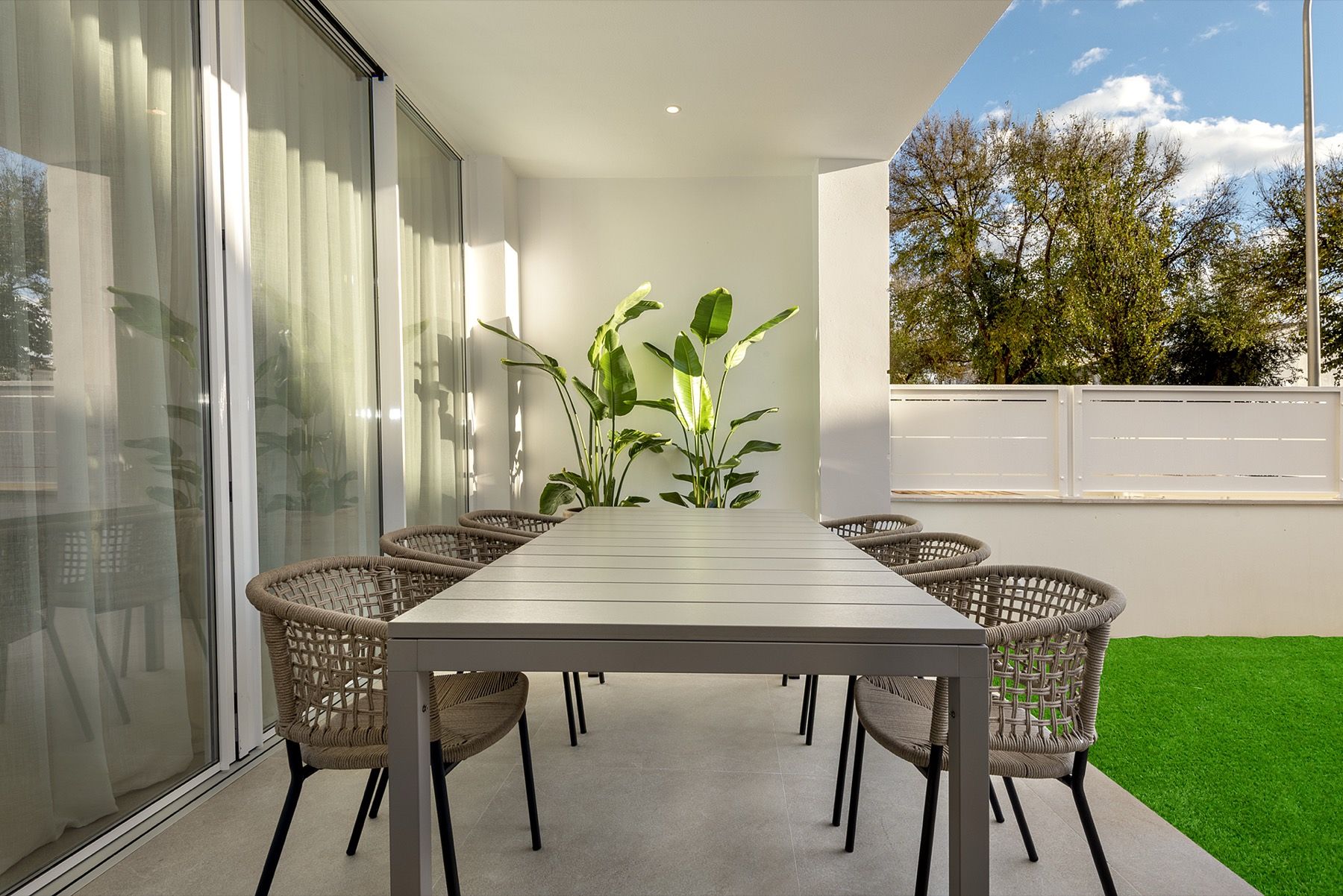 Covered terrace with dining table and garden